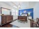 Charming bedroom boasts a dark wood dresser with a blue accent wall and tray ceiling at 2447 Louisville St, Charleston, SC 29492