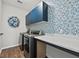 Well-lit laundry room featuring blue cabinets, patterned wallpaper, and modern washer and dryer units at 260 Dunlin Dr, Summerville, SC 29486