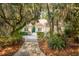 Charming home exterior featuring lush landscaping, mossy trees, and a inviting walkway to the front door at 2737 Old Forest Dr, Seabrook Island, SC 29455