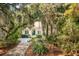 Inviting home exterior showcasing mature trees, manicured landscaping, and a quaint walkway to the front door at 2737 Old Forest Dr, Seabrook Island, SC 29455