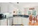 Kitchen area with stainless steel sink, black countertops, white cabinets, and open view to the dining area at 2737 Old Forest Dr, Seabrook Island, SC 29455