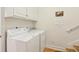 Bright laundry area featuring a white washer and dryer set and upper cabinets for convenient storage at 2737 Old Forest Dr, Seabrook Island, SC 29455