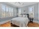 Well-lit bedroom with hardwood floors, a king-size bed, and windows with white shutters at 278 Furman Farm Pl, Daniel Island, SC 29492