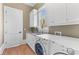 Efficient laundry room with modern washer and dryer, white cabinetry, and ample countertop space at 278 Furman Farm Pl, Daniel Island, SC 29492