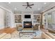 Elegant living room with built-in bookcases, a fireplace, and French doors at 278 Furman Farm Pl, Daniel Island, SC 29492