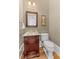 Traditional powder room with hardwood floors, granite vanity, and decorative artwork at 278 Furman Farm Pl, Daniel Island, SC 29492