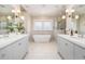Spa-like bathroom featuring double vanities, a freestanding tub, and a glass-enclosed shower at 2906 Palm Blvd, Isle of Palms, SC 29451