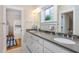Bathroom featuring double sinks, white cabinets, and a doorway to a room with bunk beds at 2906 Palm Blvd, Isle of Palms, SC 29451