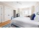Well-lit bedroom featuring a blue metal bed frame, a large window, and hardwood floors at 2906 Palm Blvd, Isle of Palms, SC 29451