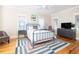 Cozy bedroom with a blue metal bed frame, natural light, and hardwood floors at 2906 Palm Blvd, Isle of Palms, SC 29451