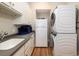 Well-organized laundry room with sink, cabinets, countertop, refrigerator, and stacked washer/dryer at 2906 Palm Blvd, Isle of Palms, SC 29451