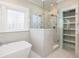 Luxurious walk-in shower with dual showerheads, built-in shelving, and marble tile at 2906 Palm Blvd, Isle of Palms, SC 29451