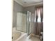 Clean bathroom showcasing a tub with glass enclosure and window with privacy curtains at 3073 Moonlight Dr, Charleston, SC 29414