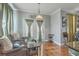 Warm sitting area features french doors, comfortable wicker chairs, and a chandelier to create an inviting space at 3073 Moonlight Dr, Charleston, SC 29414
