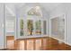 Bright foyer with hardwood floors, transom window, and glass double doors to the exterior at 3180 Pine Needle Ln, Seabrook Island, SC 29455