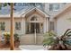 Welcoming front entrance with an arched window, wooden stairs, and lush landscaping at 3180 Pine Needle Ln, Seabrook Island, SC 29455
