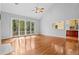 Spacious living room with hardwood floors, large glass doors, and access to the kitchen at 3180 Pine Needle Ln, Seabrook Island, SC 29455
