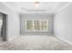 Bright main bedroom features a trey ceiling, neutral carpet, and a large window with backyard views at 3180 Pine Needle Ln, Seabrook Island, SC 29455