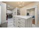 Spacious closet with a central island and a laundry area, illuminated by a stylish chandelier at 3708 Colonel Vanderhorst Cir, Mount Pleasant, SC 29466