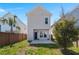 A shot of the backyard featuring grass, partial trees, and a concrete back patio with windows and black doors at 384 Ripple Park Dr, Summerville, SC 29486