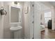 Powder room with pedestal sink and decorative mirror, adjacent to an open doorway leading into a living area at 384 Ripple Park Dr, Summerville, SC 29486