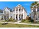 Inviting two-story home with a double porch, lush landscaping, and a welcoming front exterior at 384 Ripple Park Dr, Summerville, SC 29486