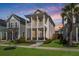 Charming two-story home with a double porch, showcasing a landscaped yard and a beautiful sunset backdrop at 384 Ripple Park Dr, Summerville, SC 29486