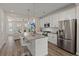 Open concept kitchen with stainless steel appliances, granite countertops, pendant lighting, and island seating flowing into living area at 384 Ripple Park Dr, Summerville, SC 29486