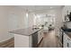 Spacious kitchen with island, stainless steel dishwasher, and view into the living room with comfortable white sofa at 384 Ripple Park Dr, Summerville, SC 29486
