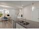 Kitchen island with stainless steel sink and faucet, pendant lights, and view into a home office with desk and chair at 384 Ripple Park Dr, Summerville, SC 29486