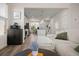 Bright living room flowing into the kitchen, hardwood floors, and comfortable white sofa with green accents at 384 Ripple Park Dr, Summerville, SC 29486