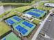 Aerial view of new blue and green tennis courts surrounded by a pond and trees at 384 Ripple Park Dr, Summerville, SC 29486
