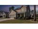 Inviting two-story home at dusk with a manicured lawn, attached garage, and a charming front porch, perfect for relaxing at 505 Kilarney Rd, Summerville, SC 29483