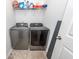 Modern laundry room with stainless steel Samsung washer and dryer and overhead shelving at 505 Kilarney Rd, Summerville, SC 29483