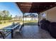 Cozy covered patio with outdoor dining and grill, overlooking a well-manicured backyard at 505 Kilarney Rd, Summerville, SC 29483