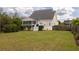 Exterior view of the home showcasing the back yard, screened in porch, and well-maintained landscaping at 545 Two Mile Run, Johns Island, SC 29455