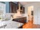 Kitchen featuring granite countertops, stainless steel faucet, dark wood cabinetry, and hardwood floors at 545 Two Mile Run, Johns Island, SC 29455