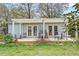 The home's backyard features a deck with outdoor seating, lush greenery, and mature trees at 633 Schooner Rd, Charleston, SC 29412