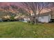 Spacious backyard at dusk with mature trees, grass, and an inviting patio area, ideal for outdoor relaxation and enjoyment at 633 Schooner Rd, Charleston, SC 29412