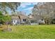 Large backyard with a well-maintained lawn, mature trees, and a patio, ideal for outdoor activities at 633 Schooner Rd, Charleston, SC 29412