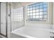 Bathroom featuring a soaking tub and a glass block window at 8208 Little Sydneys Way, North Charleston, SC 29406