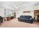 Cozy living room with a ceiling fan, plush seating, bookshelves, and a large window at 8208 Little Sydneys Way, North Charleston, SC 29406