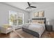 A styled bedroom featuring a bed, large window, art, and hardwood floors at 874 Colony Drive # B19, Charleston, SC 29407