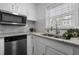 Modern kitchen with stainless steel microwave and appliances, complemented by granite countertops and backsplash at 874 Colony Drive # B19, Charleston, SC 29407