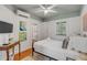 Bedroom with hardwood floors, ceiling fan, TV, and an en-suite bathroom at 90 Spring St # Ab, Charleston, SC 29403