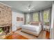 A main bedroom features wood floors, a brick fireplace, and ample natural light from multiple windows at 90 Spring St # Ab, Charleston, SC 29403