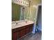 A bathroom featuring double sinks, a large mirror, and tile floors for style and functionality at 9028 Maple Grove Dr, Summerville, SC 29485