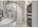Modern bathroom featuring marble shower, sleek fixtures, and contemporary stacked washer/dryer at 928 Ashley Ave, Charleston, SC 29403