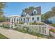 Charming home with a well-manicured lawn, white picket fence, and a decorative pergola at 928 Ashley Ave, Charleston, SC 29403