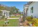 Landscaped front yard with a birdbath and a decorative white pergola at 928 Ashley Ave, Charleston, SC 29403